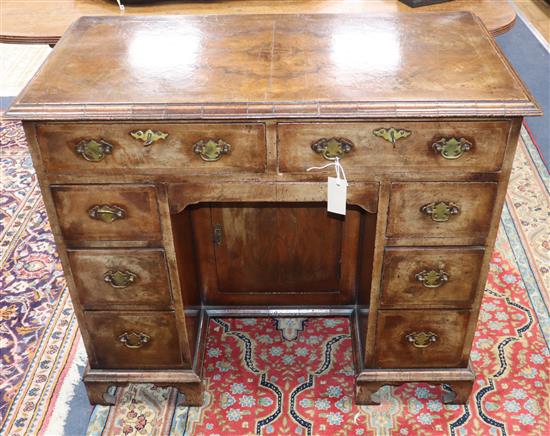 An early 20th century Queen Anne style walnut kneehole desk W.88cm